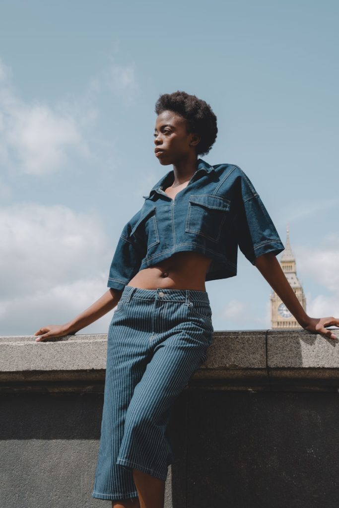 A woman poses in denim against big ben.